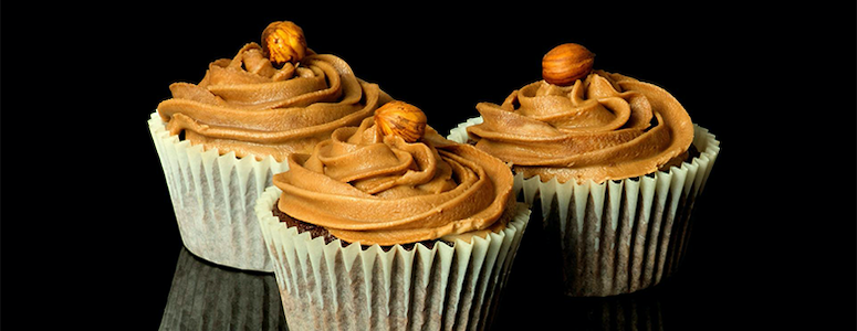 Delicious Cupcakes with frosting topped with a hazelnut Delicious Cupcakes with frosting topped with a hazelnut