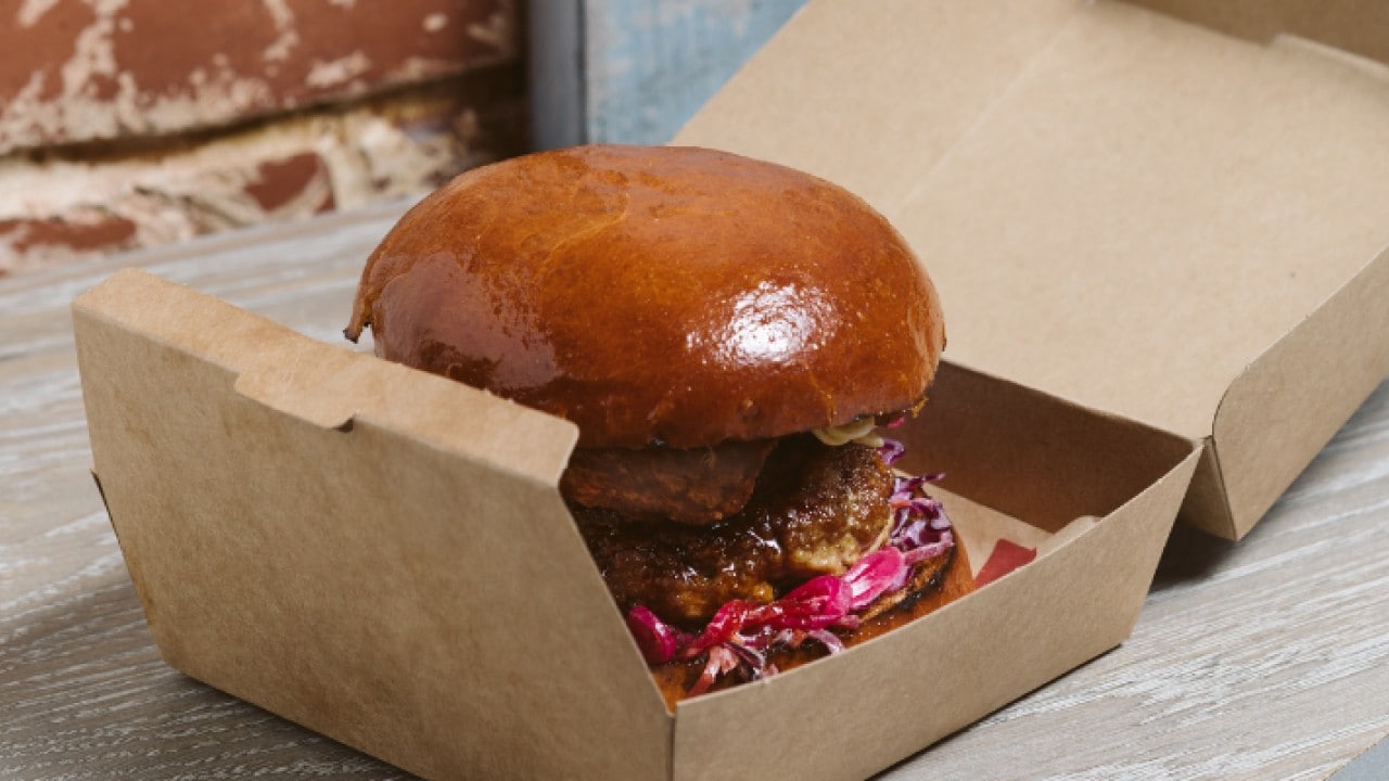 Burger placed in a sustainable cardboard takeout box. Burger placed in a sustainable cardboard takeout box.