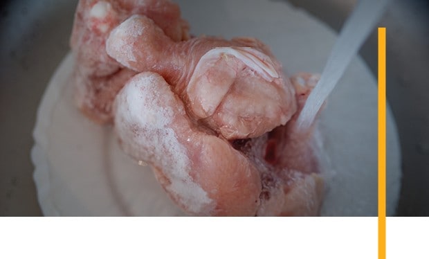 Raw chicken being cleaned and prepared. Raw chicken being cleaned and prepared.