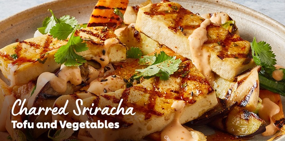A professionally plated tofu dish is shown. The text reads: Charred Siracha Tofu and Vegetables.