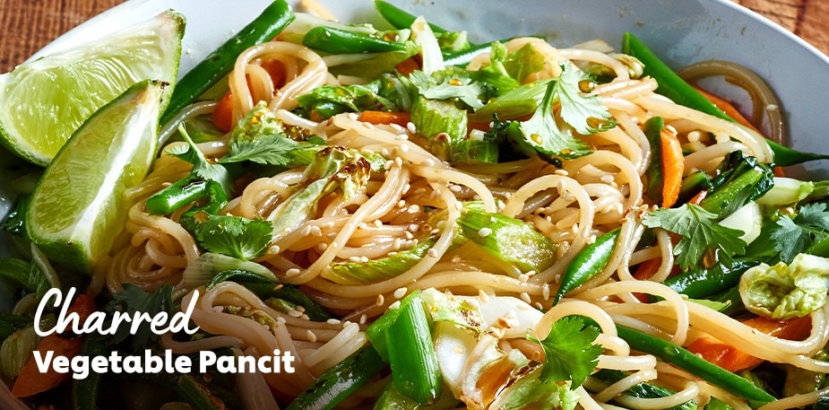 A professionally plated noodle and vegetable bowl is shown. The text reads: Charred Vegetable Pancit.