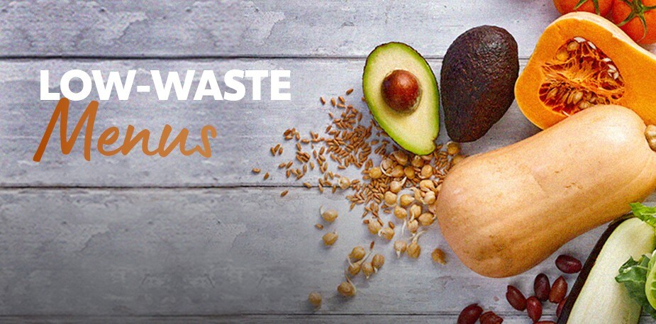 Various raw ingredients are laid on a wooden table. The text reads: Low-Waste Menus.