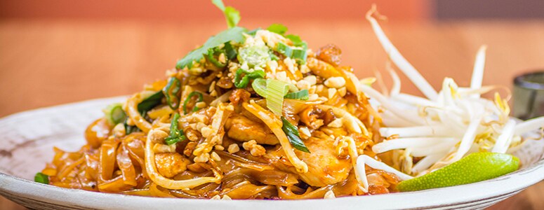 Unique Spices Aid in International Forgeries Pad Thai made with tofu topped with bean sprouts and scallions.