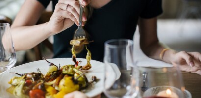 Person dining at a restaurant table. Person dining at a restaurant table.