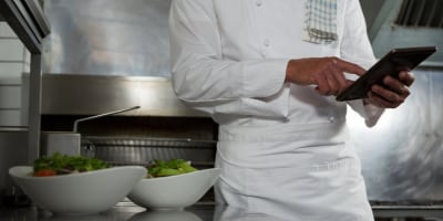 Chef in a kitchen using a tablet. Chef in a kitchen using a tablet.