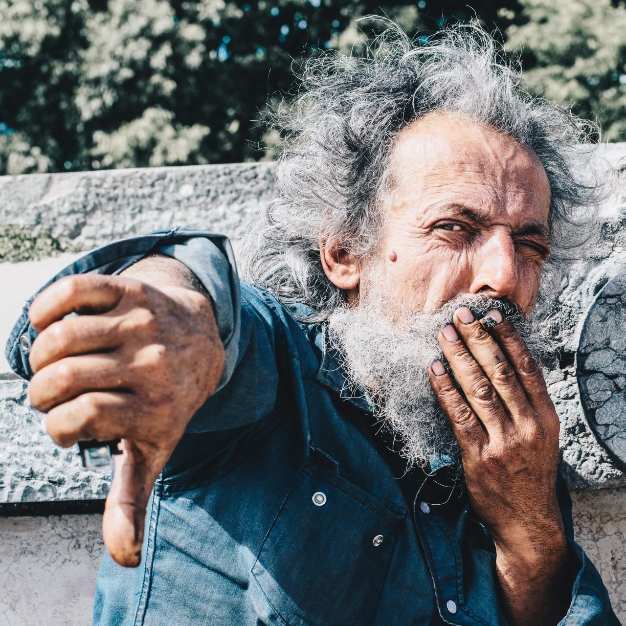 Old person smoking shows a thumbs down Old person smoking shows a thumbs down