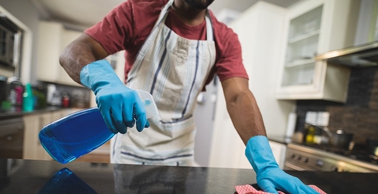 Restaurant Cleaning Checklist Chef cleaning kitchen counter tops with gloves