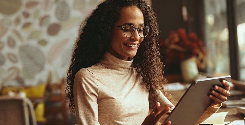 Restaurant Management Woman smiling, using a tablet to manage her restaurant