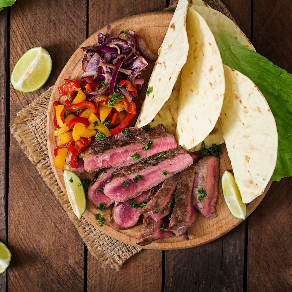 Mexican fajitas for beef steak and grilled vegetables. Top view; Shutterstock ID 390179095; purchase_order: 20210819; job: UFS NAM // Spanish Microsite; client: UFS NAM; other: DMM_Maxim